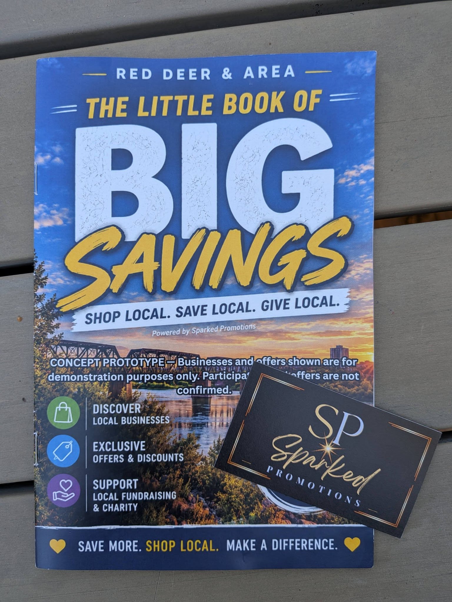 The physical Little Book prototype beside a Sparked Promotions business card